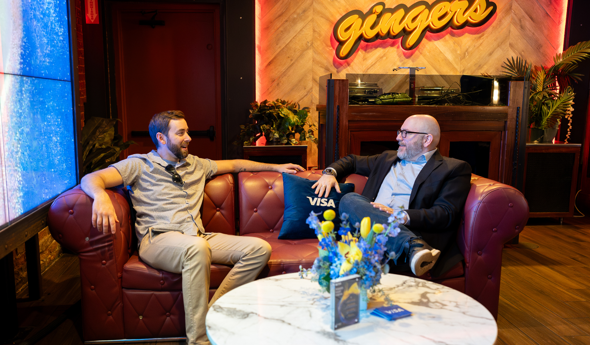 Guests chatting on leather sofas in the Visa lounge at Gingers