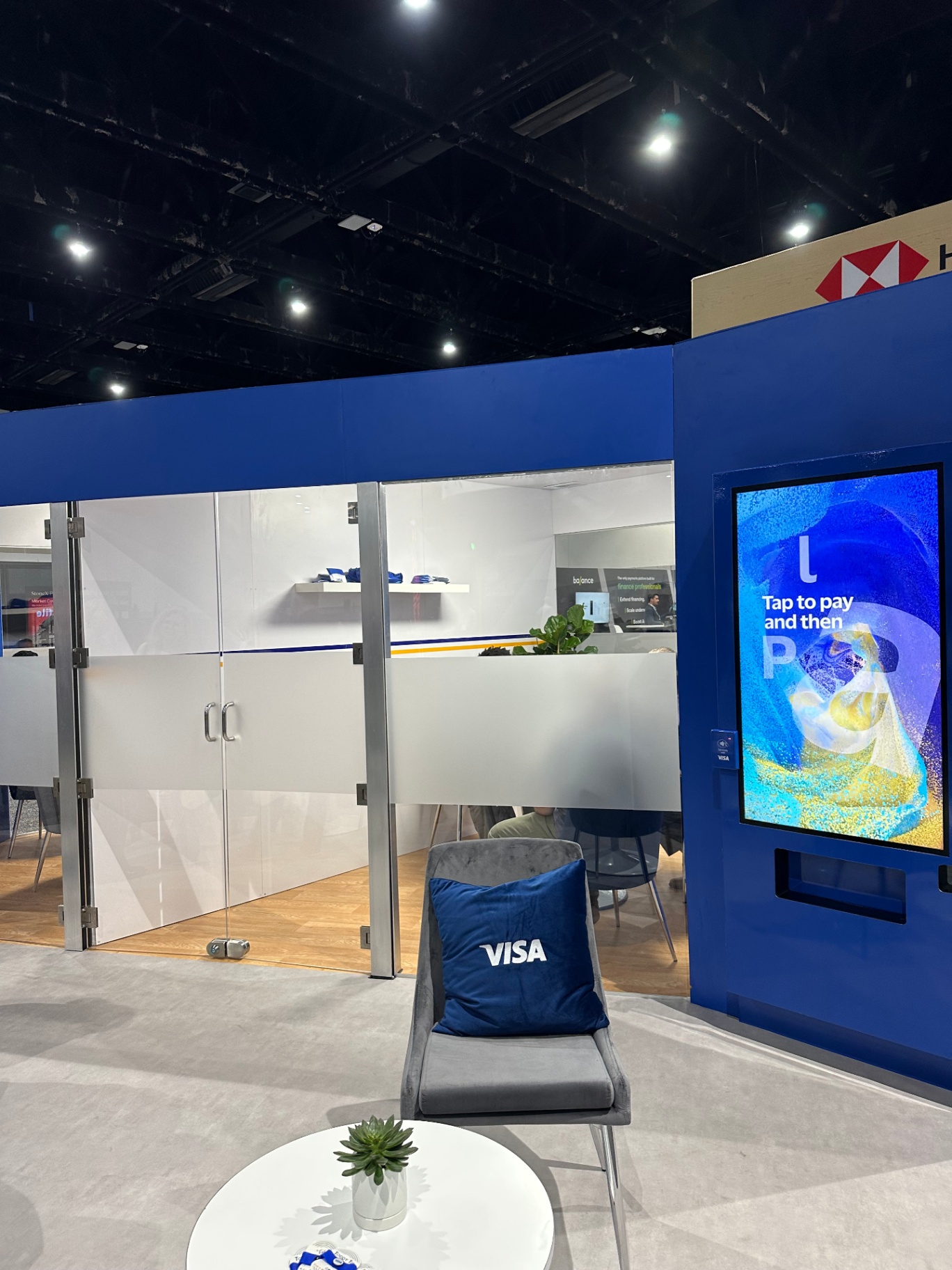 Visa lounge seating and tap-to-pay digital display at the AFP booth