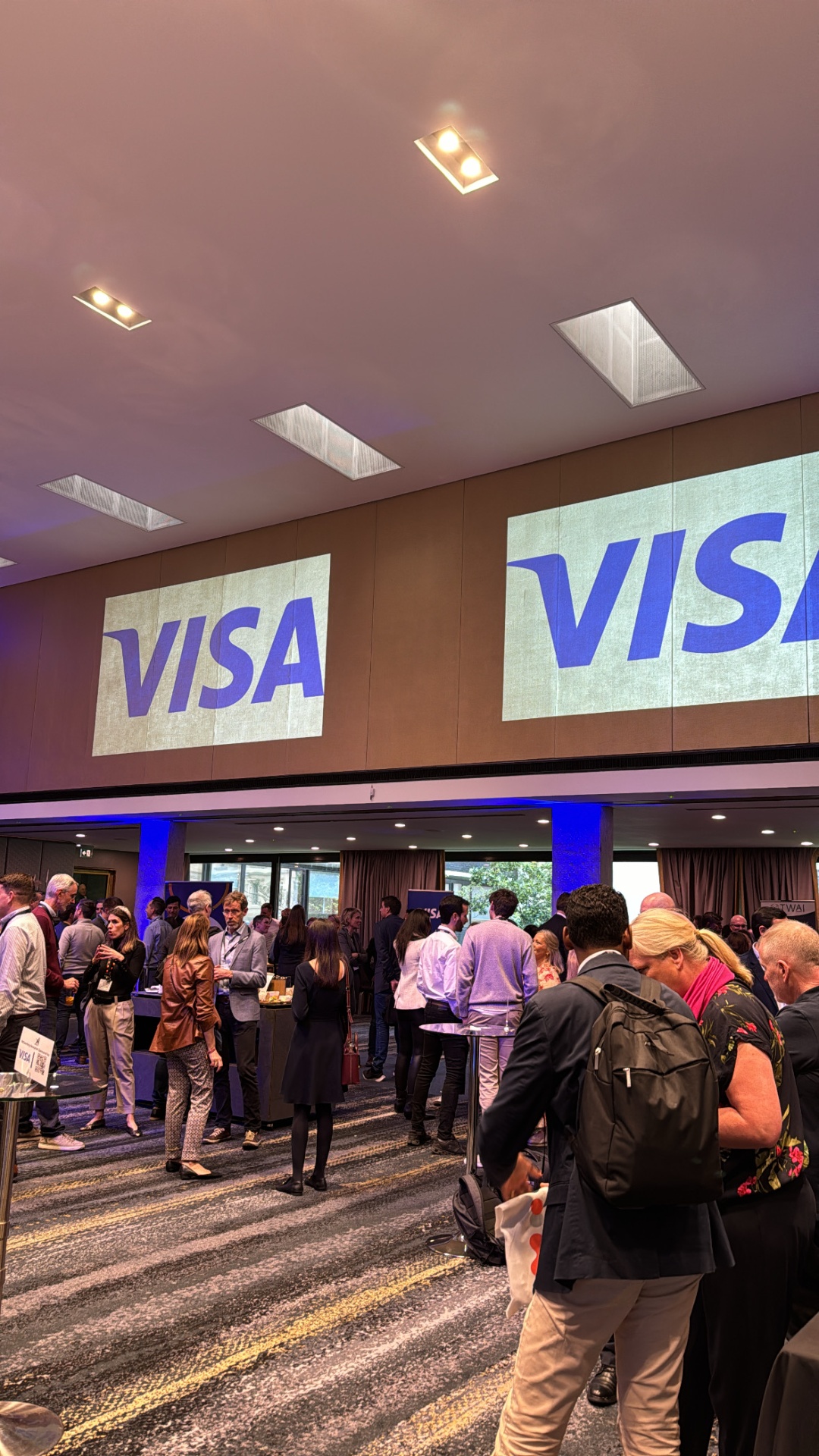 Guests networking under dual Visa projections at the ATPS reception