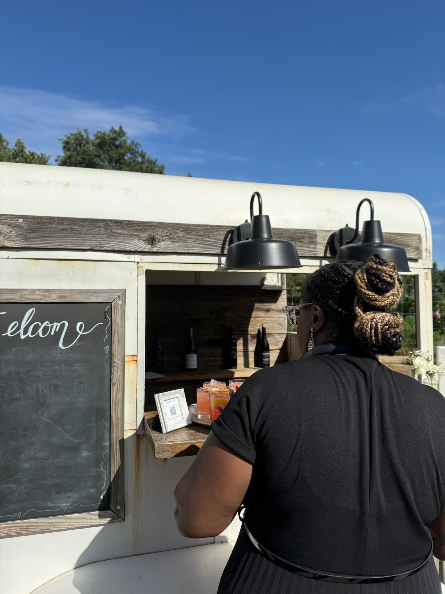 Vintage horse-trailer bar with hand-lettered welcome chalkboard and signature drinks