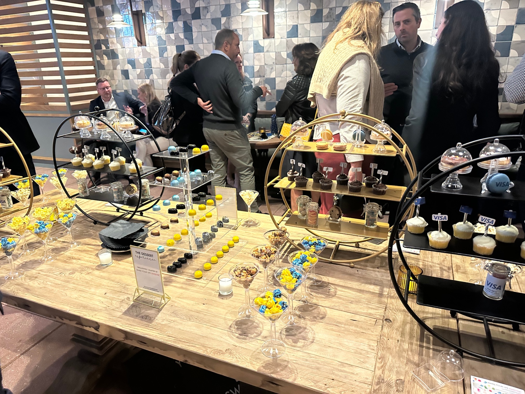 Guests mingling around the Visa dessert experience table at CPI Global 2023
