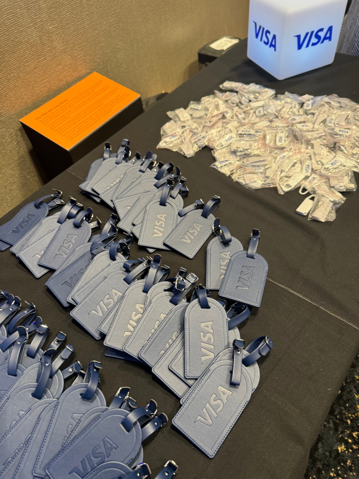 Visa leather luggage tags and branded gifts laid out on the welcome table
