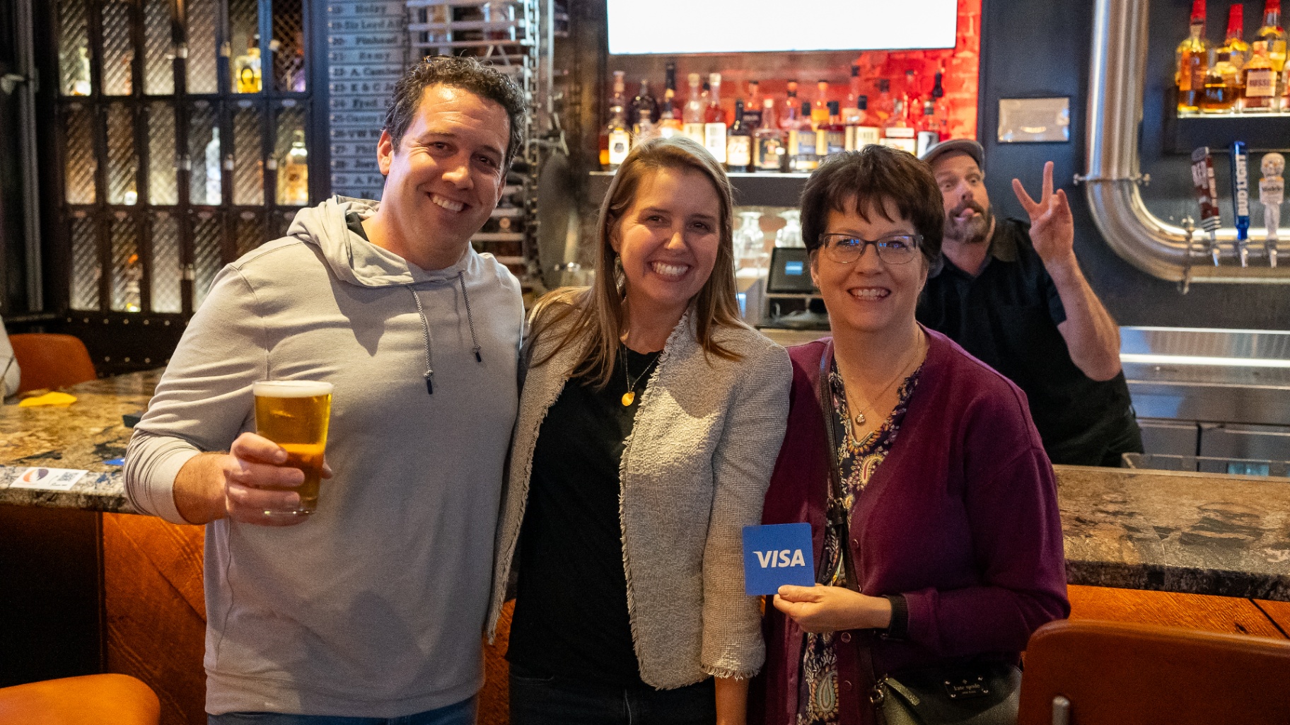 Guests posing with a Visa card at the AFP happy hour