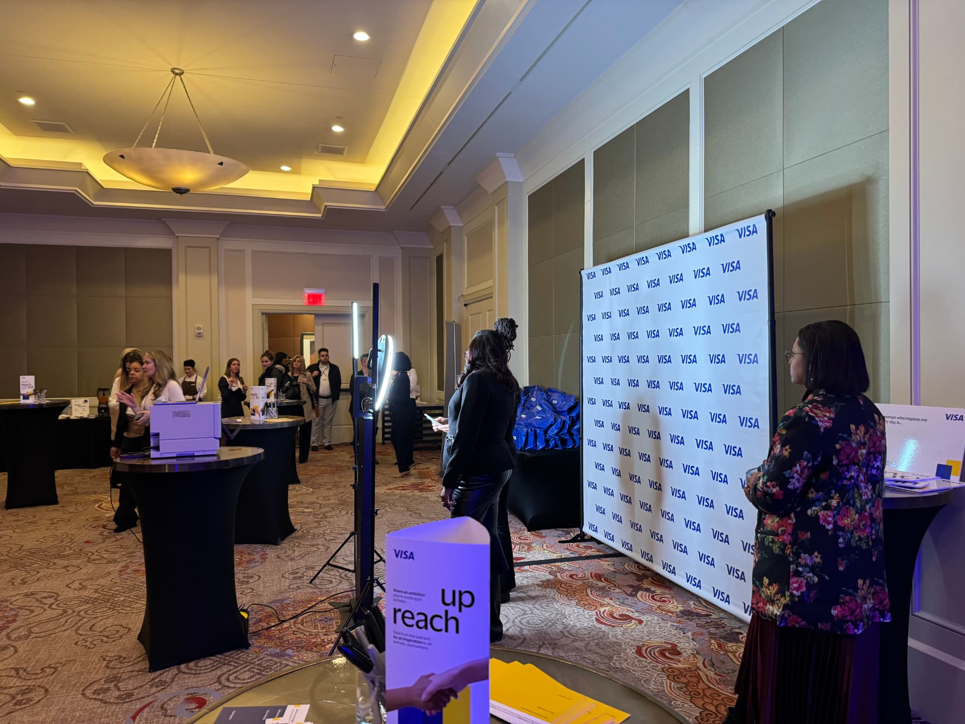 Guests at the Visa step-and-repeat photo backdrop during the reception