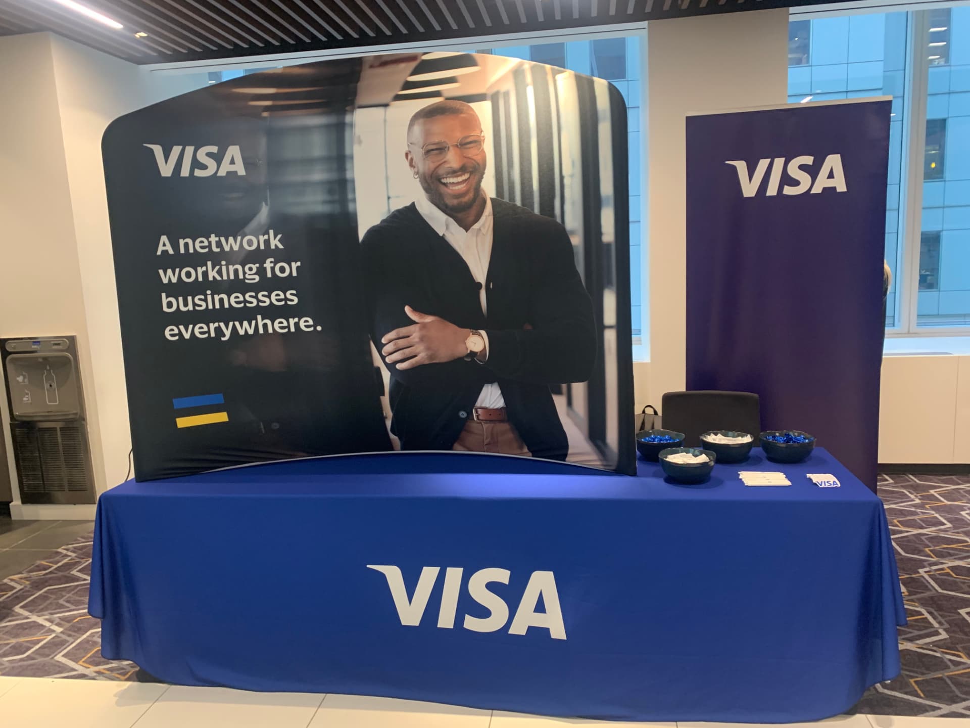 Visa booth with branded backdrop and blue table at CPI Global 2022