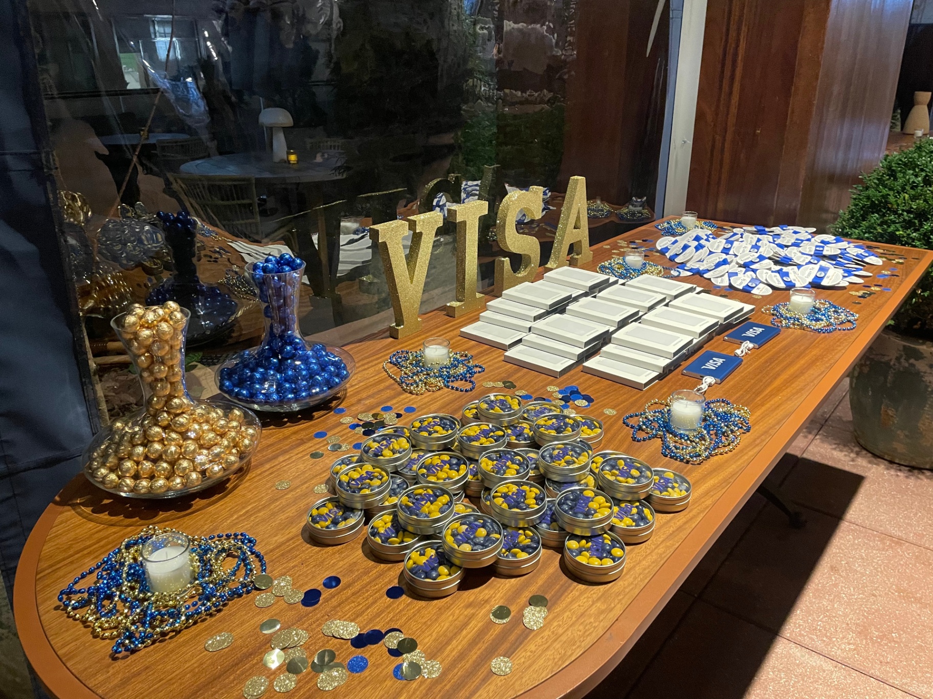 Gold Visa letters, candy tins and branded favors styled on a reception table