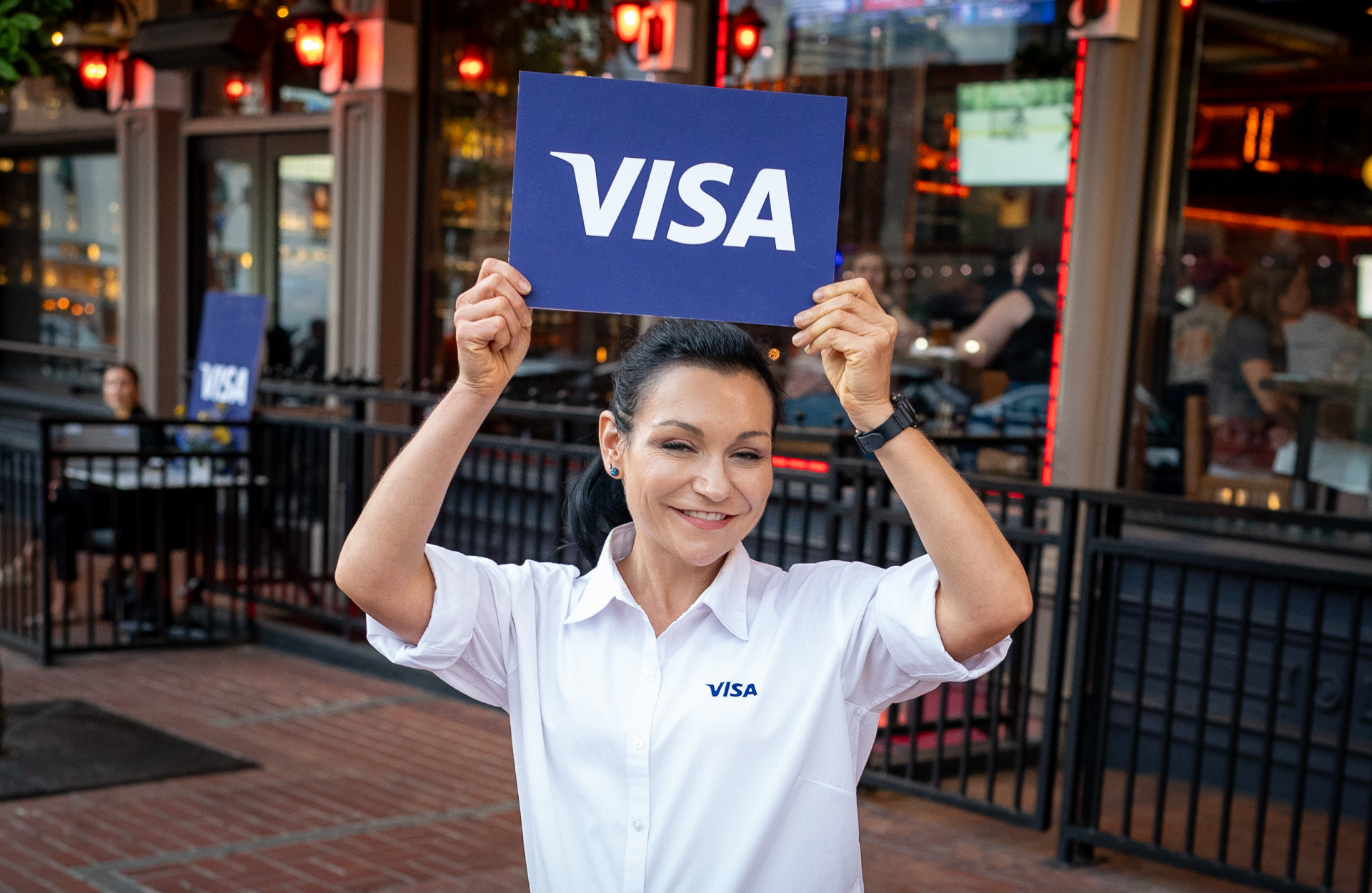 Event staff holding a Visa sign outside the AFP happy hour venue