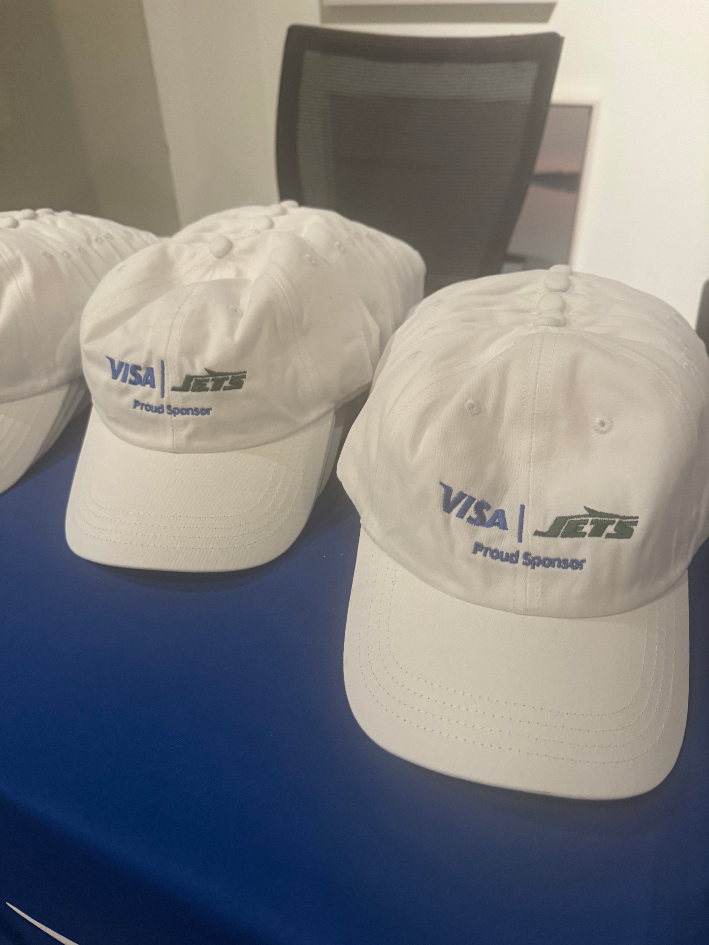 Visa and New York Jets co-branded caps lined up as guest giveaways