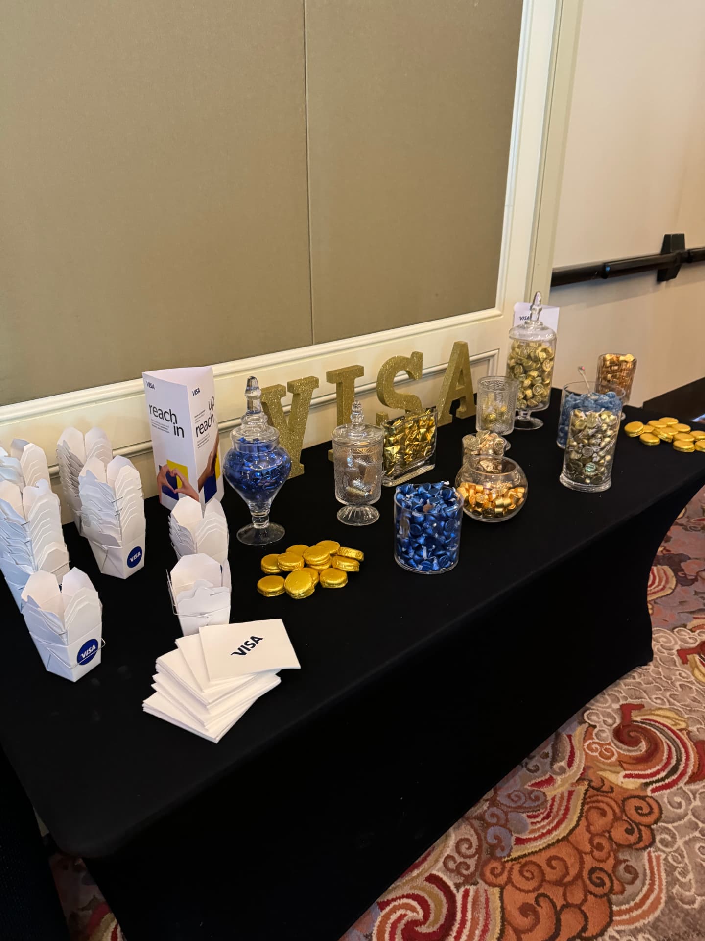 Gold VISA letters on the candy and dessert table with branded takeaway boxes