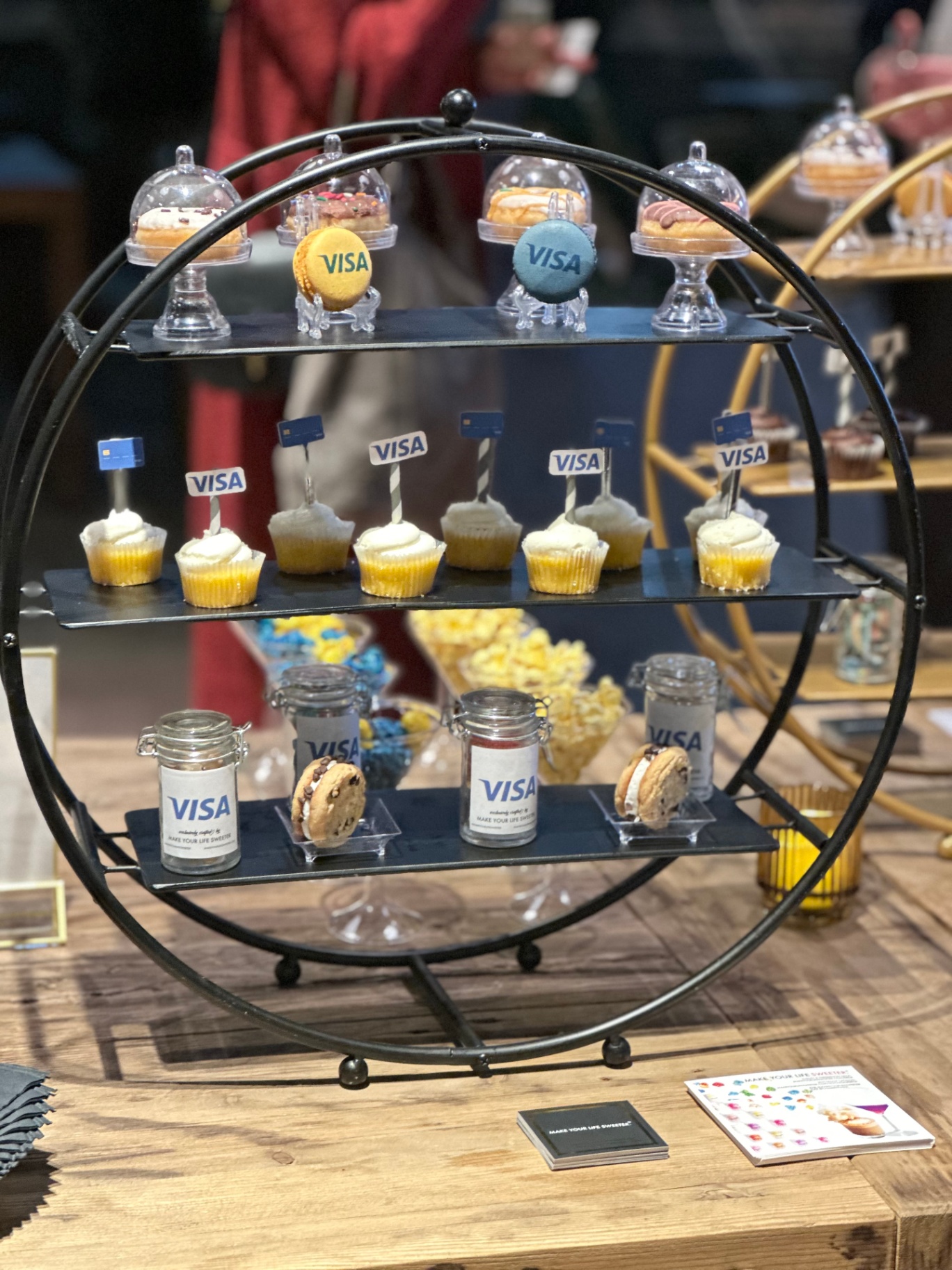 Tiered Visa dessert display with cupcakes, cookies and candy jars