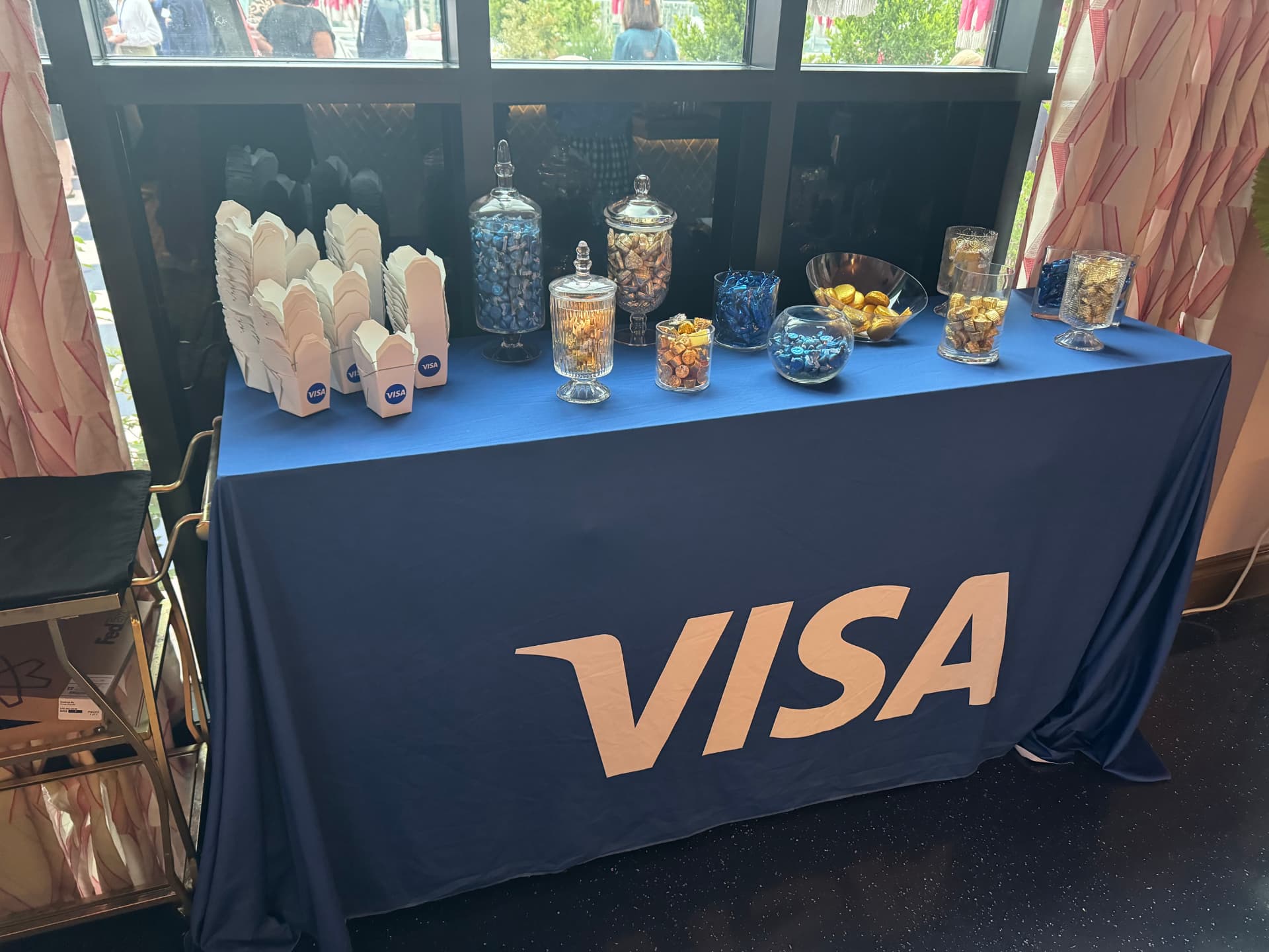 Visa-branded candy table with apothecary jars of blue and gold chocolates