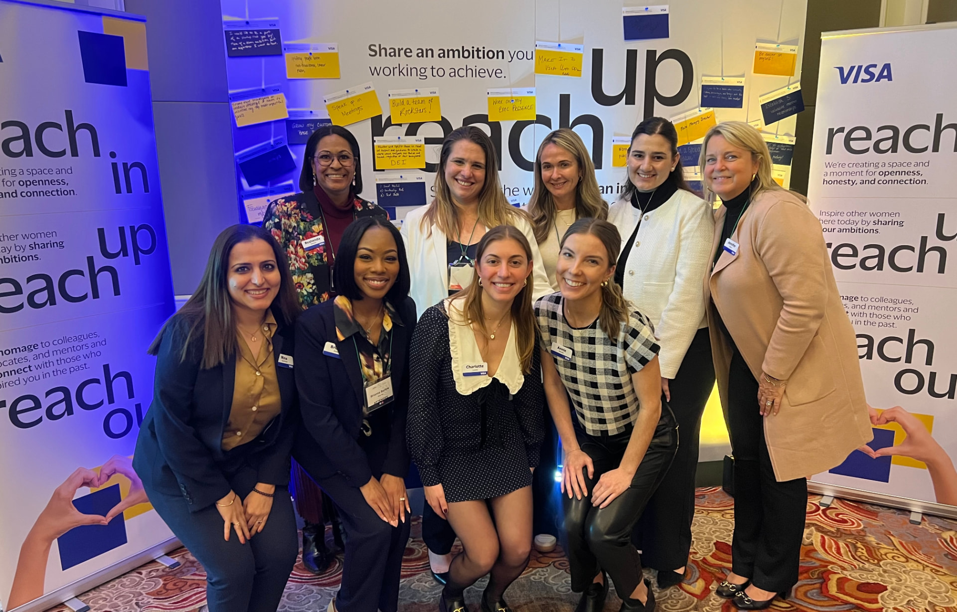 Visa team gathered in front of the reach up ambition wall at the Women in Payments symposium