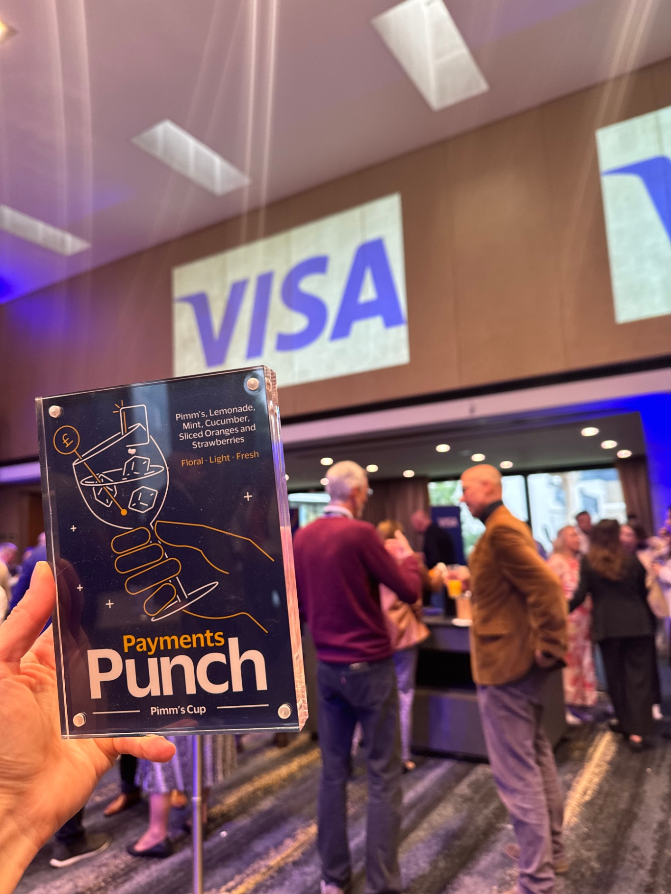 Payments Punch cocktail sign held up in front of the Visa projection wall