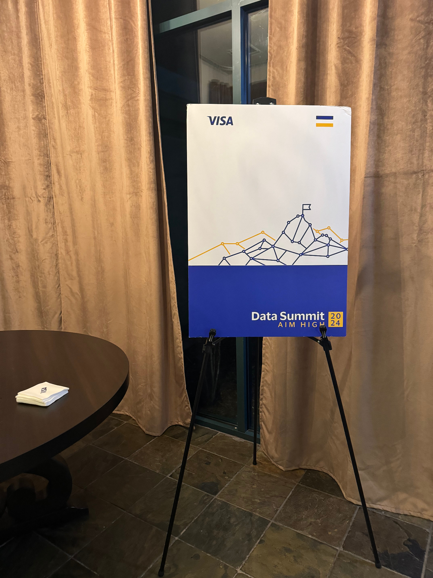 Visa Data Summit 2024 'Aim High' welcome sign on an easel