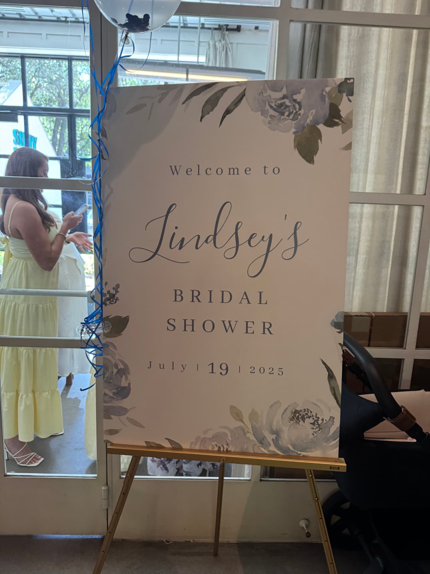 Watercolor floral welcome sign on a gold easel for Lindsey's bridal shower