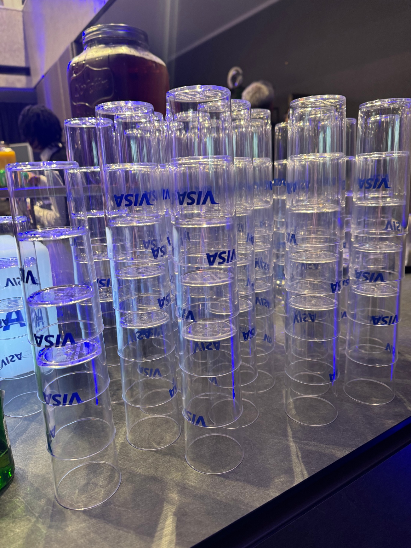 Stacks of Visa-branded highball glasses on the reception bar
