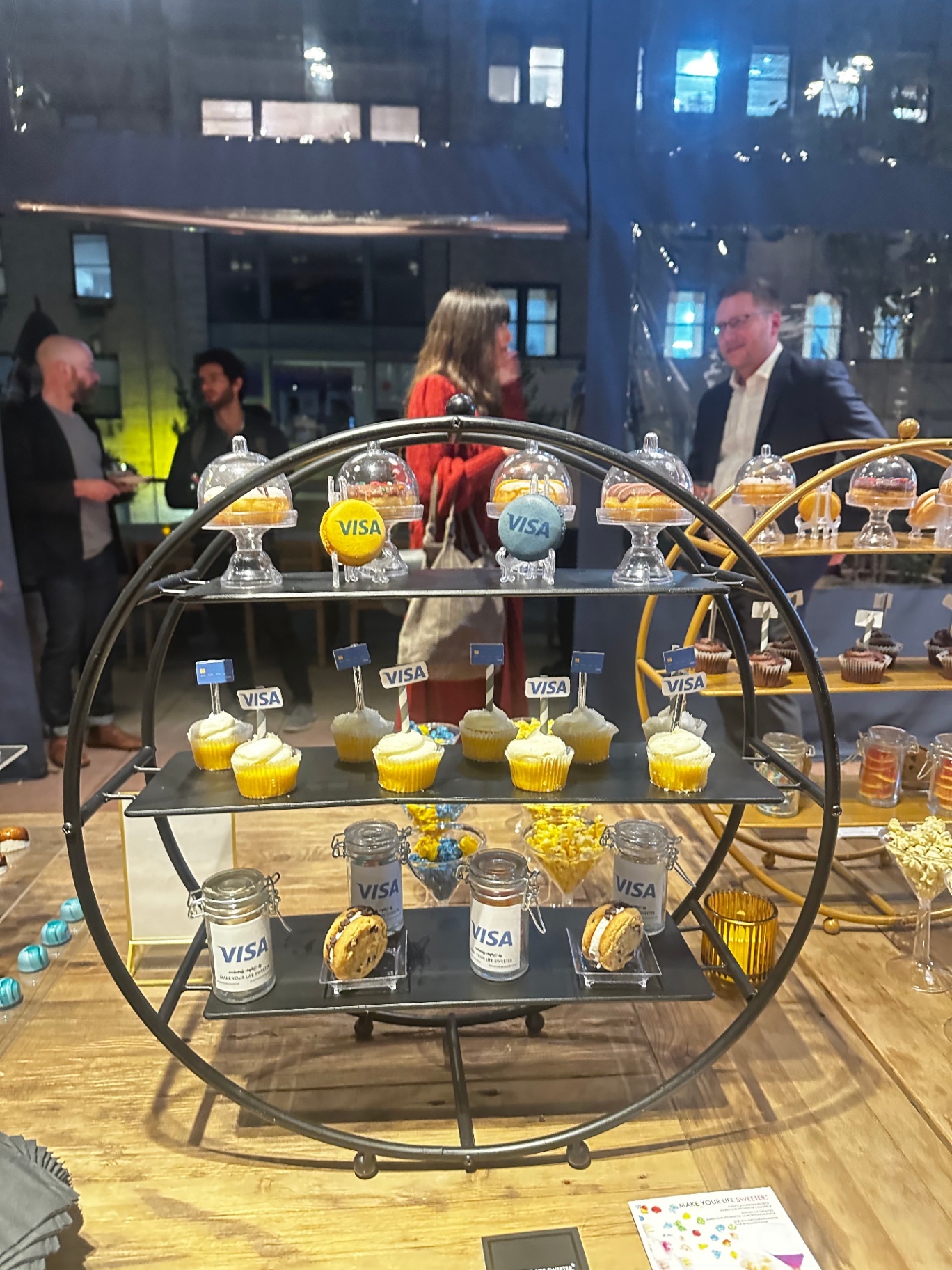 Circular dessert stand with Visa macarons, cupcakes and branded jars