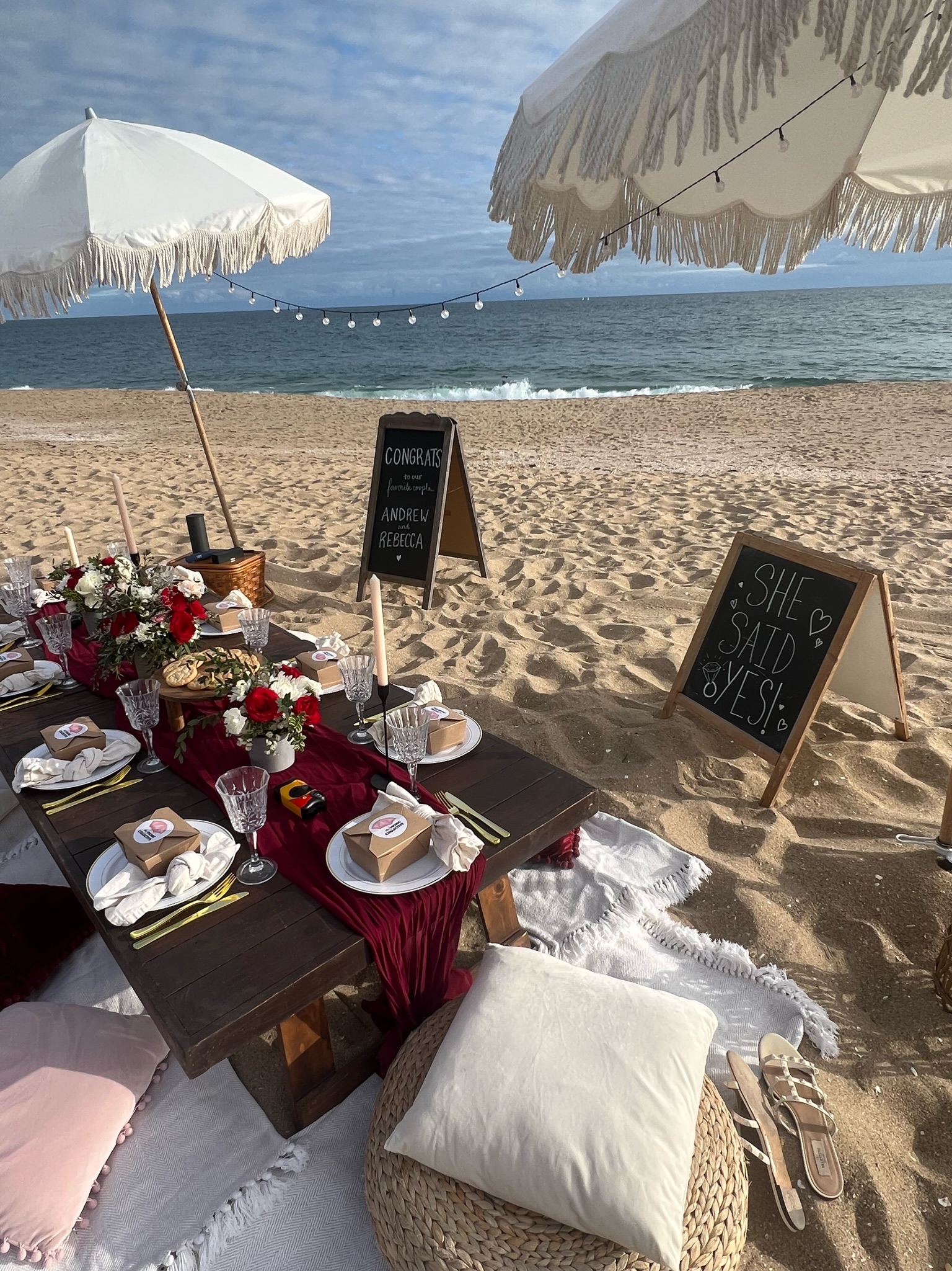 Beach engagement party - elegant setup with congratulations and 'SHE SAID YES!' signs under string lights