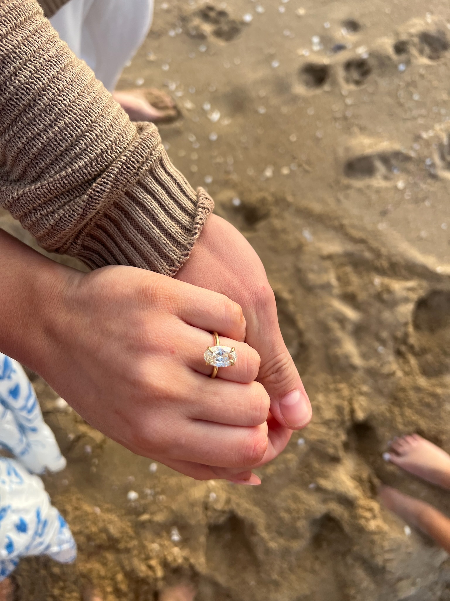 Beach engagement party - close-up of hands showing off the engagement ring on the beach